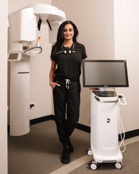 Dr Tejani stand near her work devices